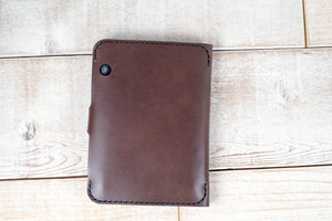 a brown leather wallet sitting on top of a wooden floor