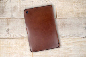 a brown leather case sitting on top of a wooden floor
